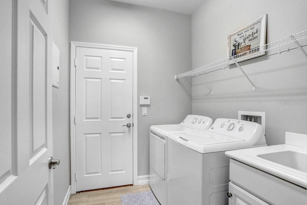 The spacious laundry room includes a UTILITY SINK and overhead storage.  The WASHER & DRYER ARE INCLUDED WITH THE PURCHASE of this home!