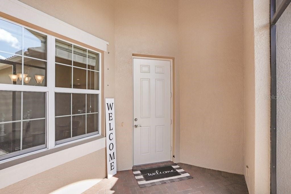 The pegs next to the windows hold the hurricane shutters which are included with purchase!  The front entrance  door is 8' tall!