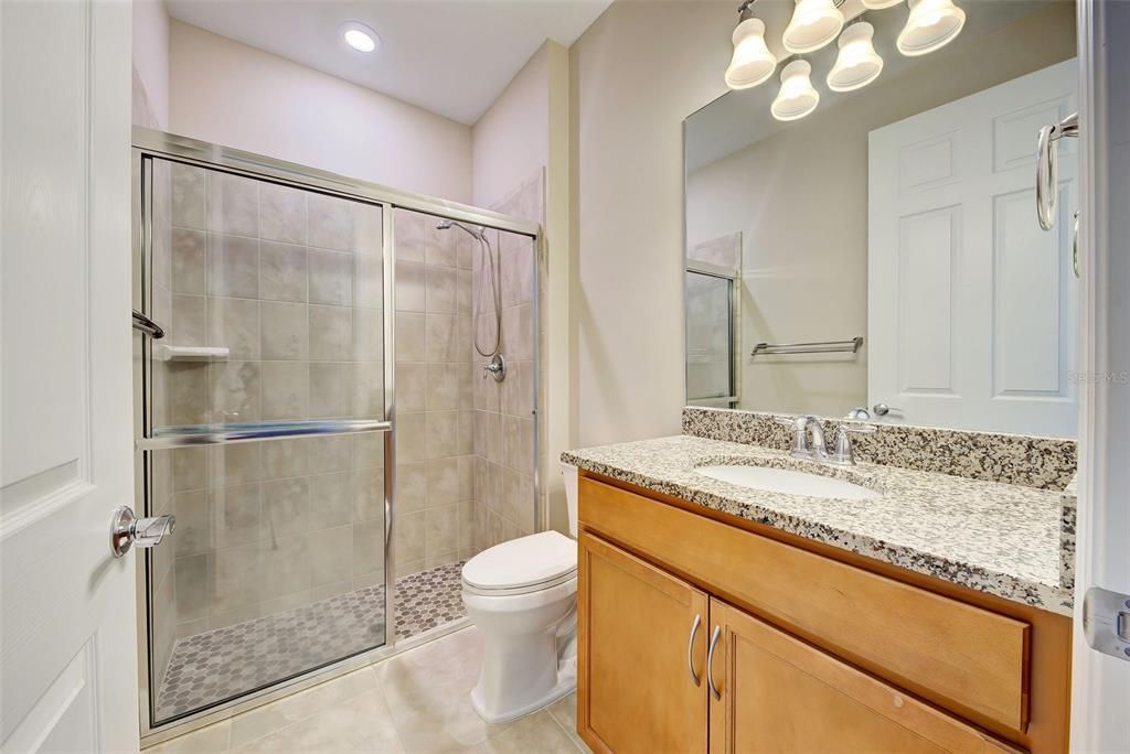 The guest bathroom has a large walk in shower.