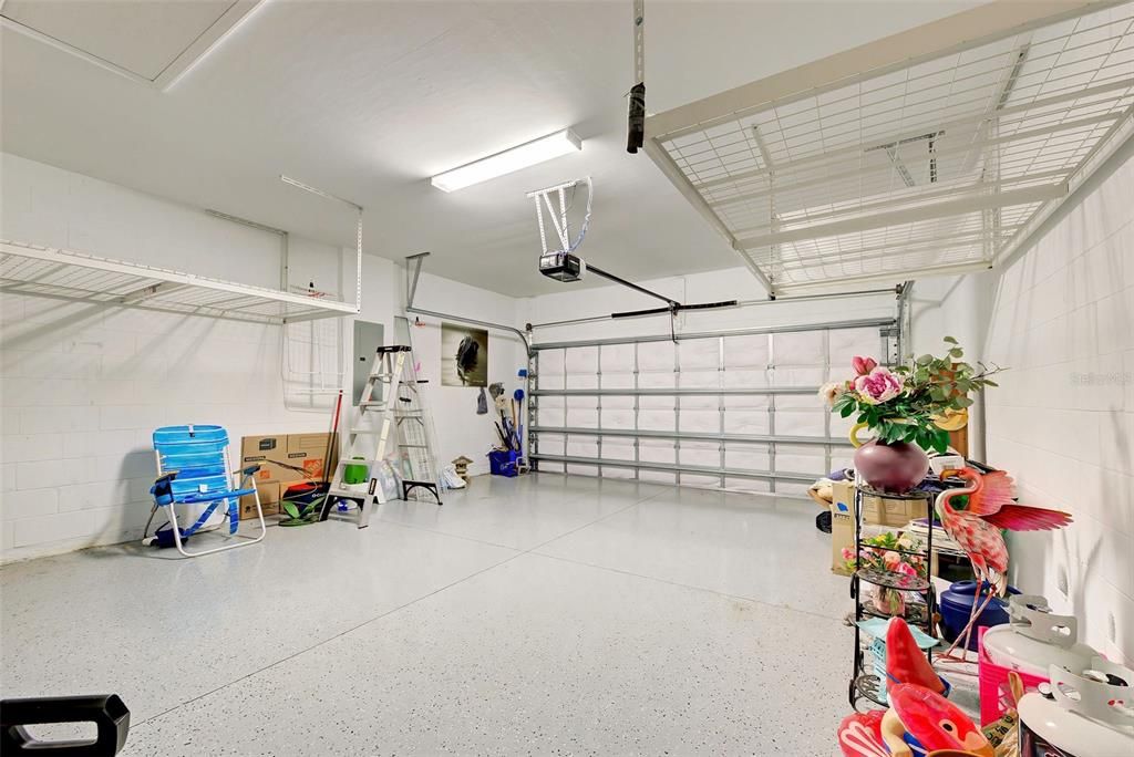 Spacious two car garage with additional overhead shelving on both sides.
