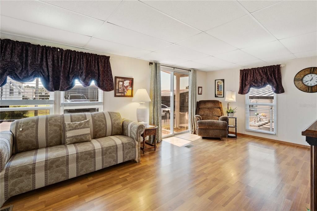 Living room has sliding door with laminate flooring.