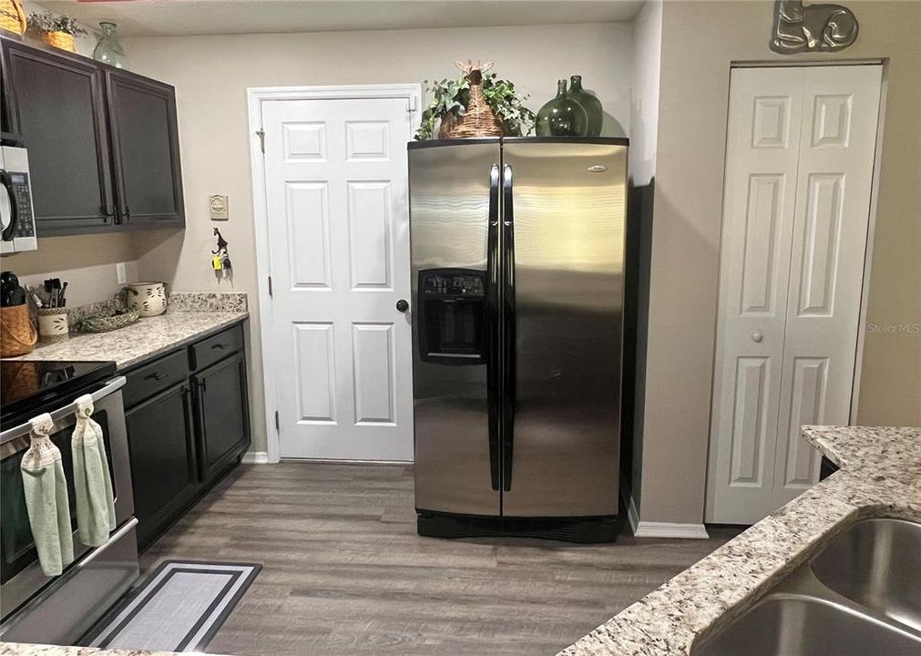 The door to the left of the fridge is the garage.