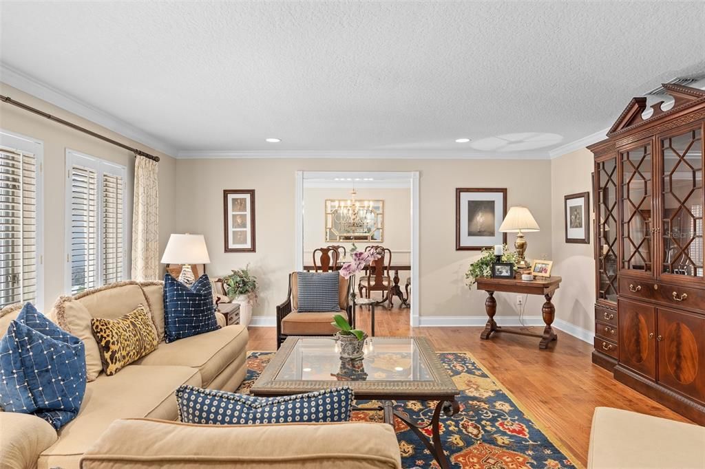 Formal Living Room Appointed With Crown Molding, Plantation Shutters and Wood Floors