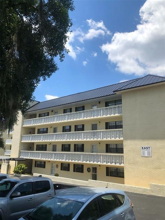 FRONT OF CONDO BUILDING WITH ELEVATOR TO THE LEFT AT COVERED ENTRY