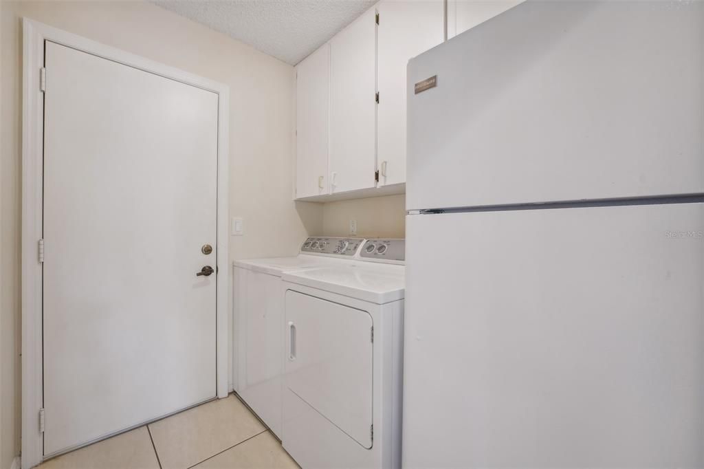 Laundry room with spare fridge