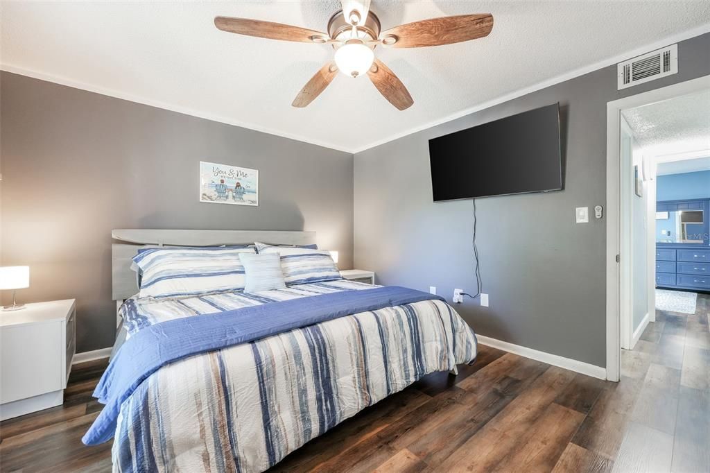 Bedroom featuring ceiling fan, dark hardwood / wood-style flooring, and ornamental molding