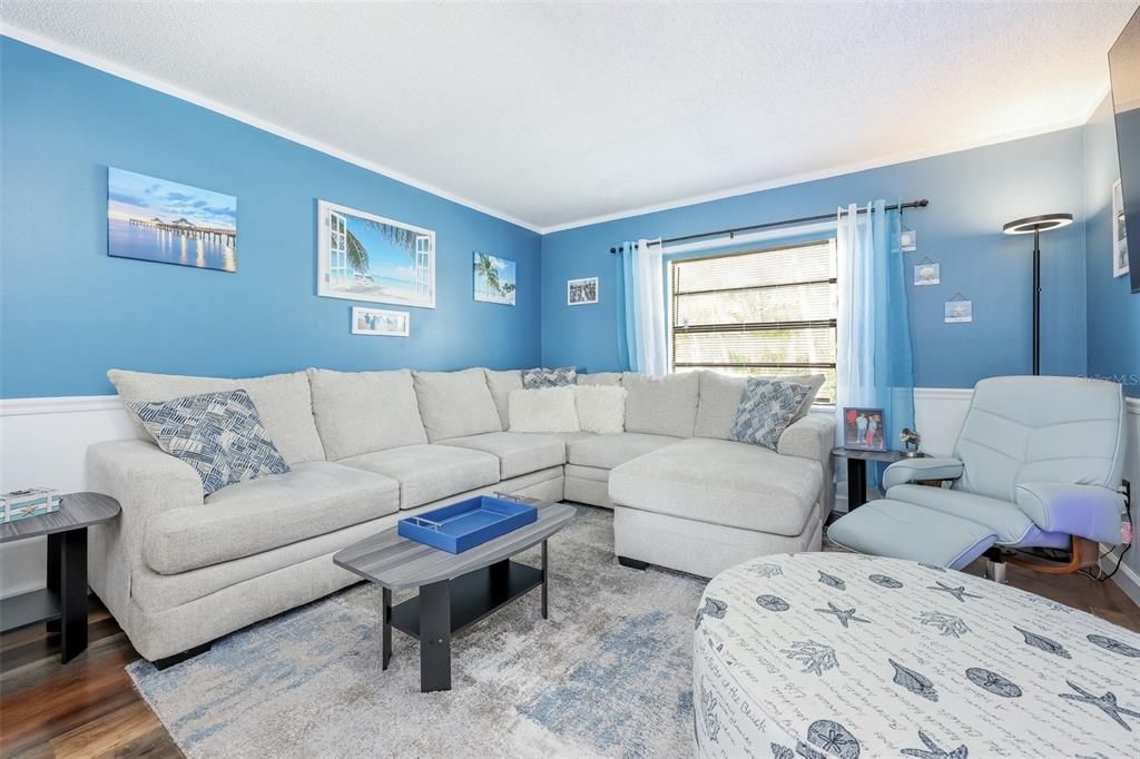 Living room with crown molding and wood-type flooring