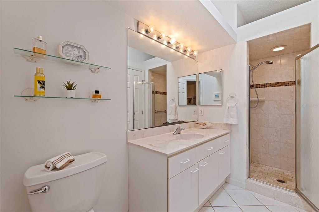 spacious primary bathroom and roomy shower stall, bonus - natural lighting!