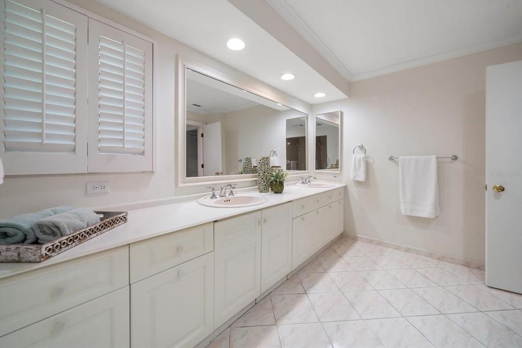 Primary suite bathroom with double vanities and extensive counter area.