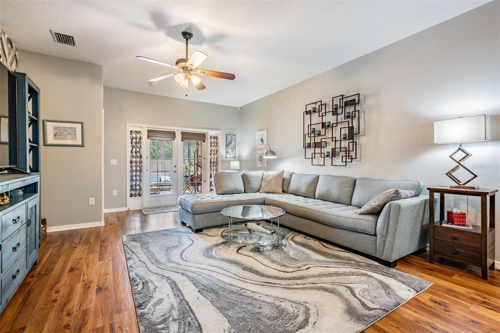 Large great room, updated Carolina Hickory flooring, ceiling fan, open to the kitchen and back patio.