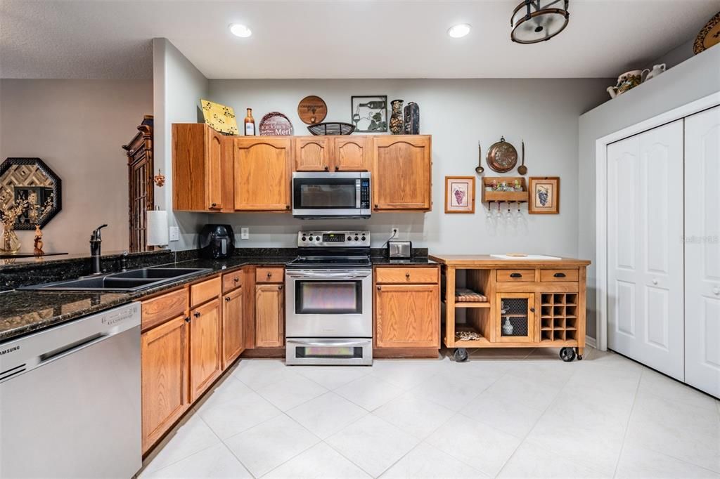 Diagonal tile flooring, inset lighting, stainless steel appliances, room to eat in the kitchen area.