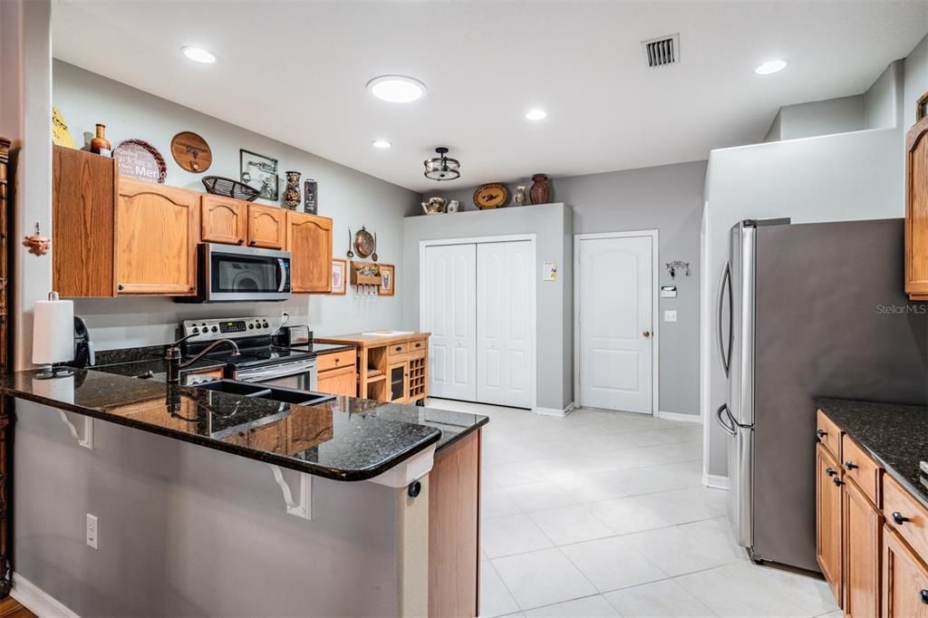 Diagonal tile flooring, inset lighting, stainless steel appliances, room to eat in the kitchen area.