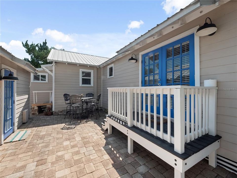 French doors to master bedroom and paver patio between house and guesthouse