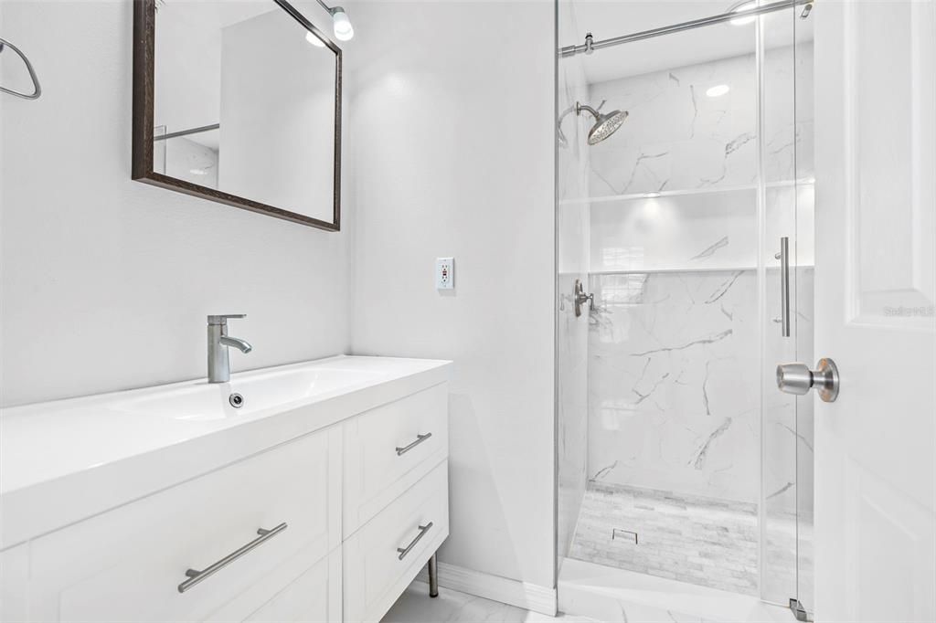 Primary bathroom with remodeled vanity and custom shower.