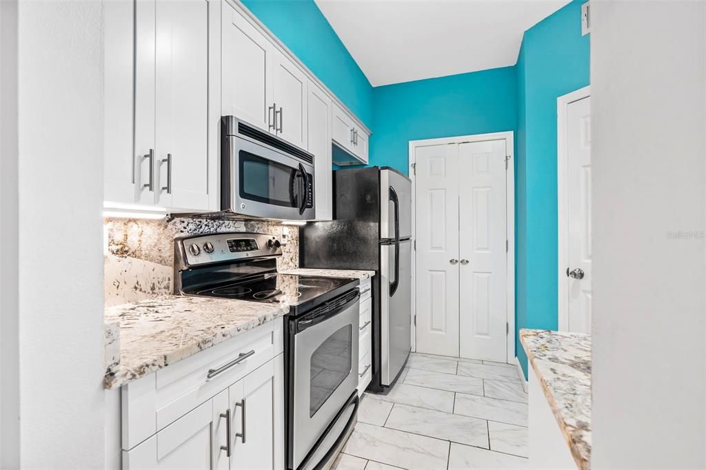 Kitchen, pantry, and functional storage access with laundry area.