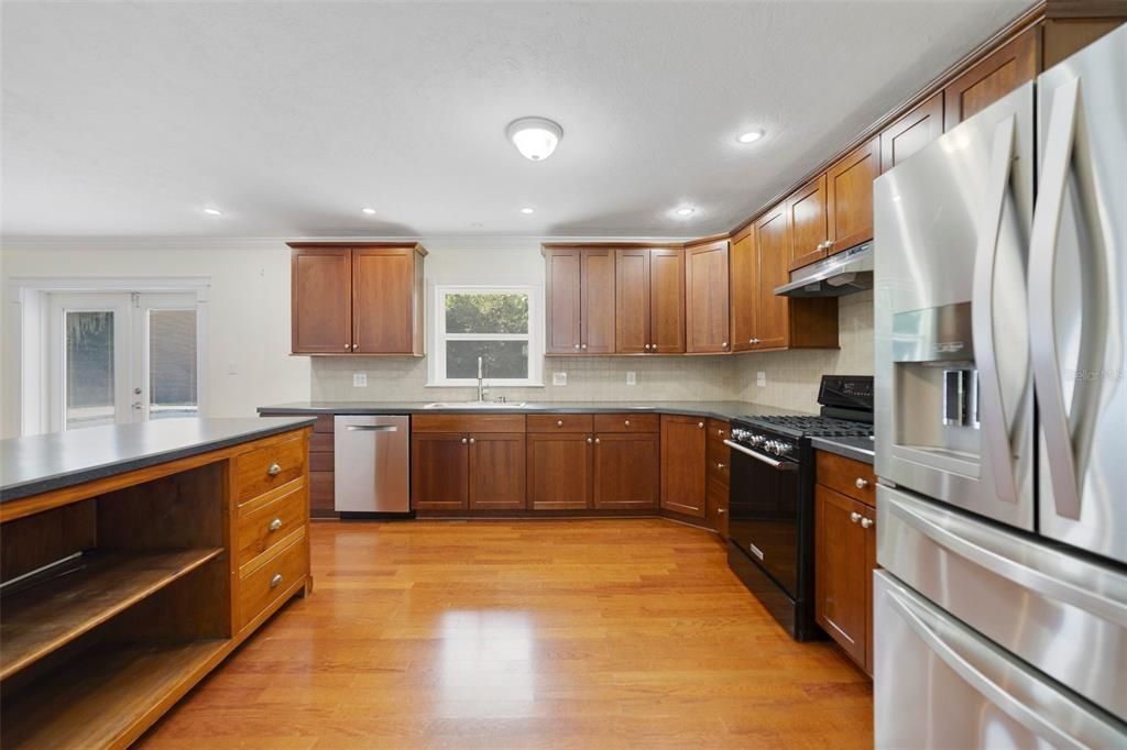 The large kitchen will delight any home chef featuring quality appliances (including a GAS STOVE!), rich solid wood cabinetry, plenty of countertop space - ISLAND and BREAKFAST BAR - and a cheery window over the sink to let the natural light pour in.