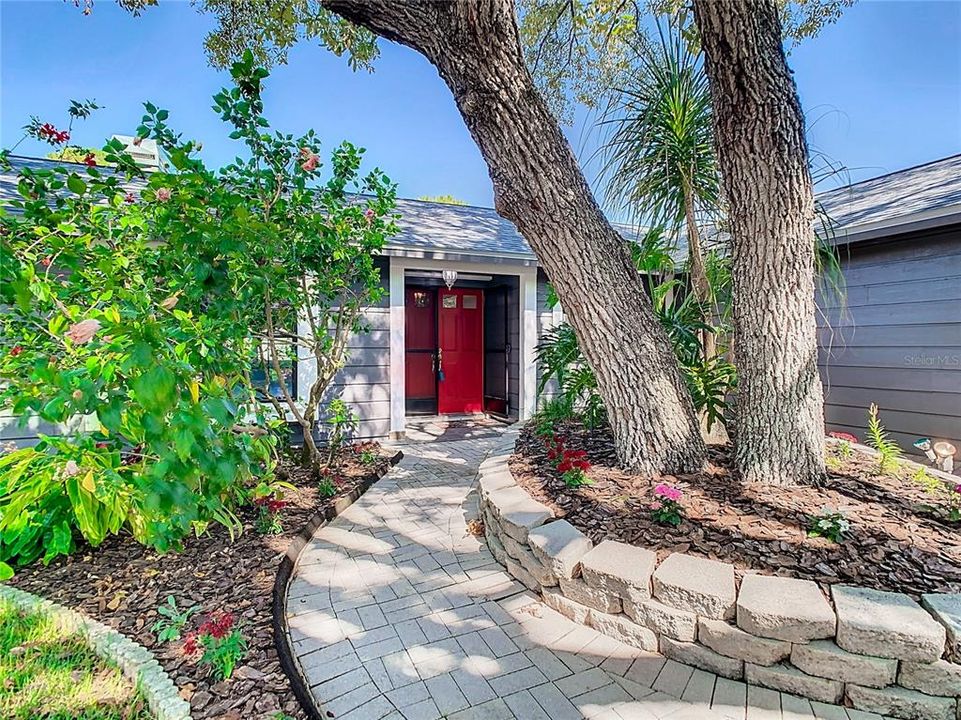 Front of house boasting mature landscaped front yard.