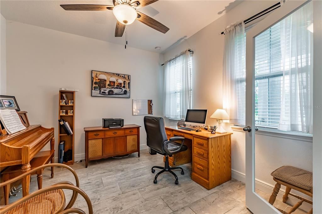 Bedroom 1 features a closet and ceiling fan and two large windows looking over the park and playground.