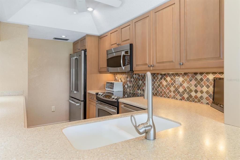 Pretty stone backsplash.  Jenn-Air refrigerator. Seamless sink.