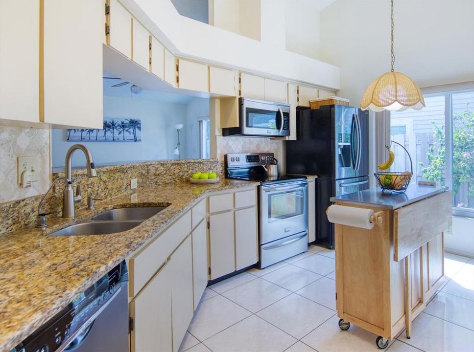 Deep double sink and rich granite counters complemented by arabesque splash walls~