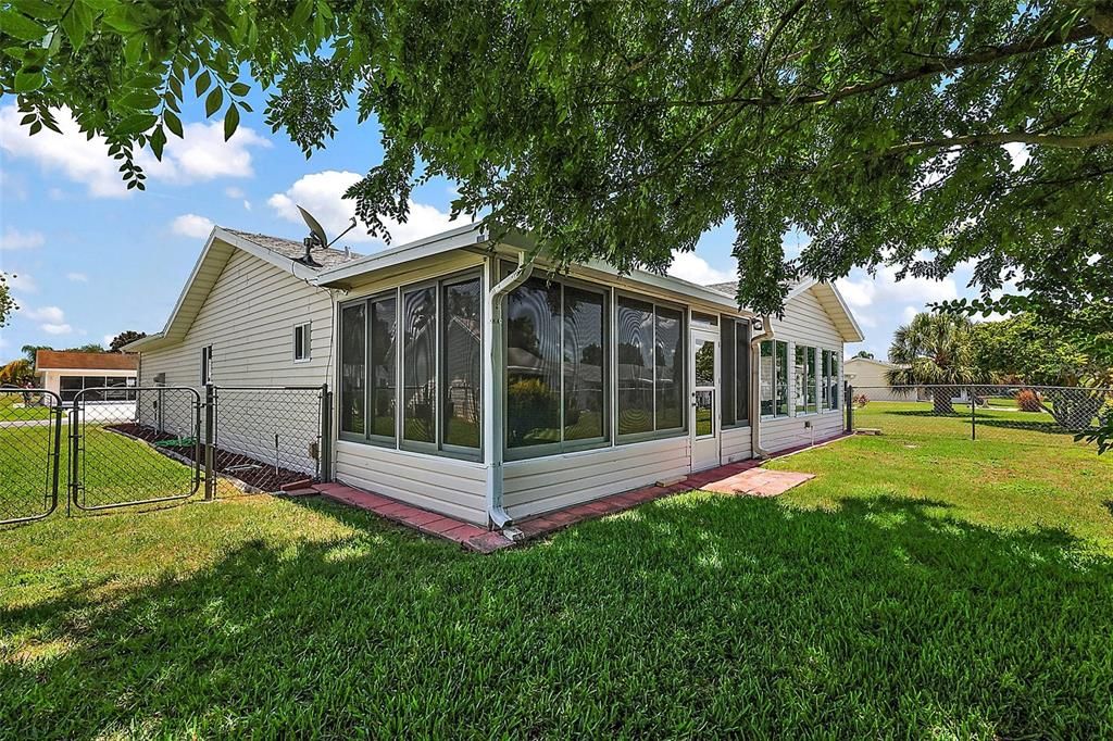 View from property corner showing lanai and fenced yard