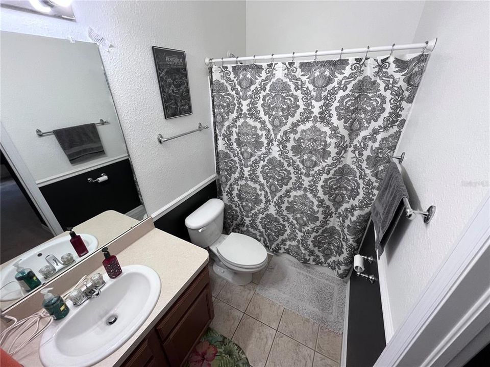 Downstairs bathroom with access to hall and tertiary bedroom.