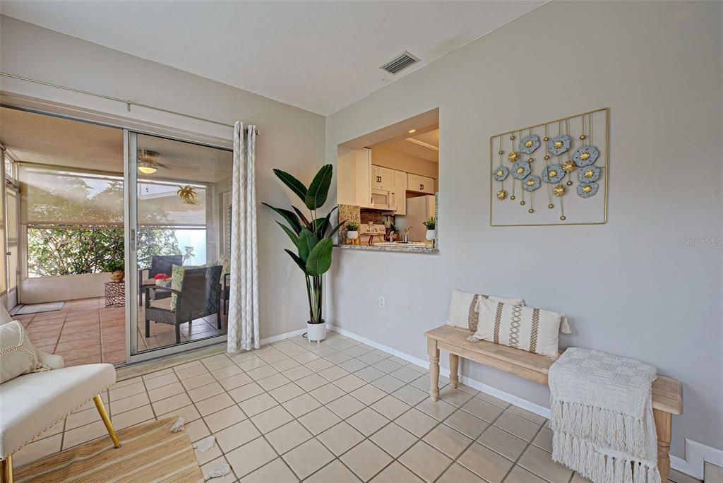 Sunroom with bar top opening to kitchen and sliding glass door to lanai.