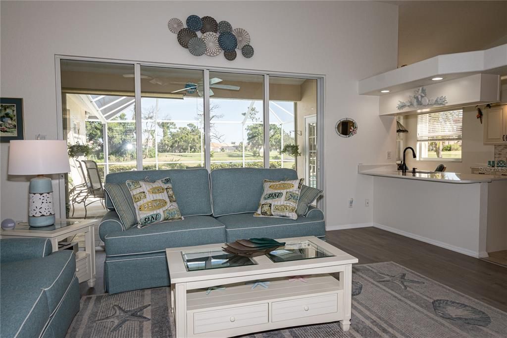 Living room opens to kitchen with sliders to the pool area