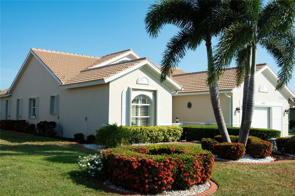 Front of the house including tropical and manicured landscaping