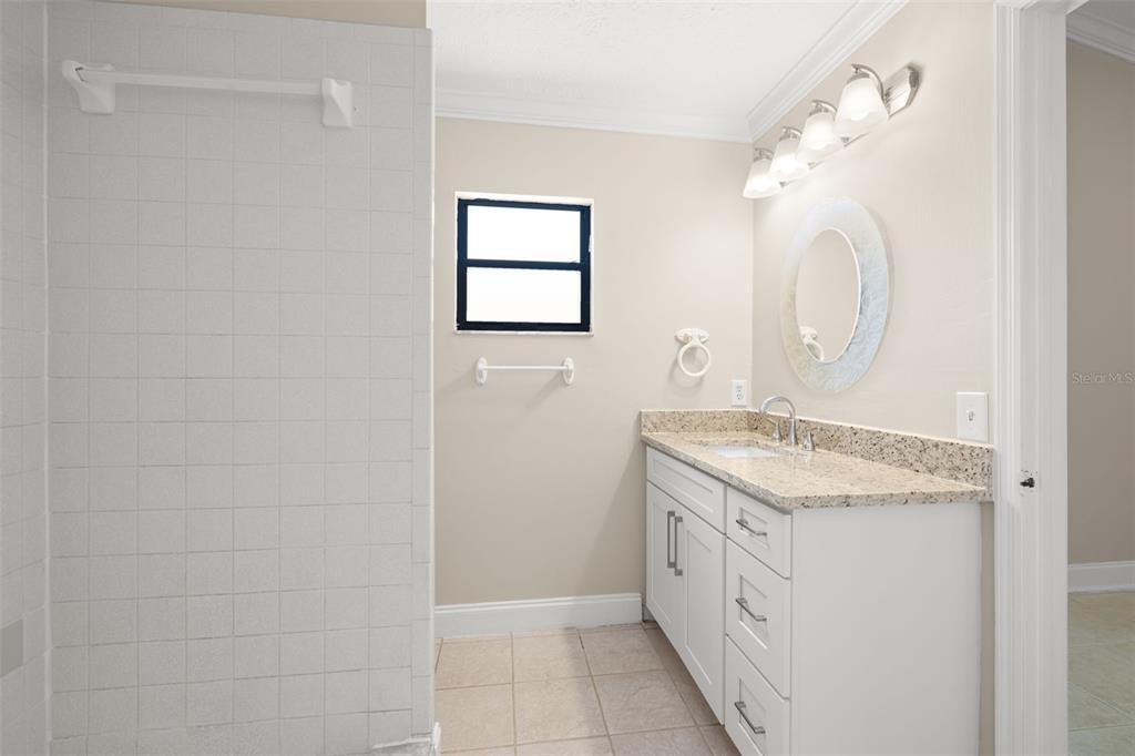 Primary bedroom includes an ensuite with granite counters for the vanity.