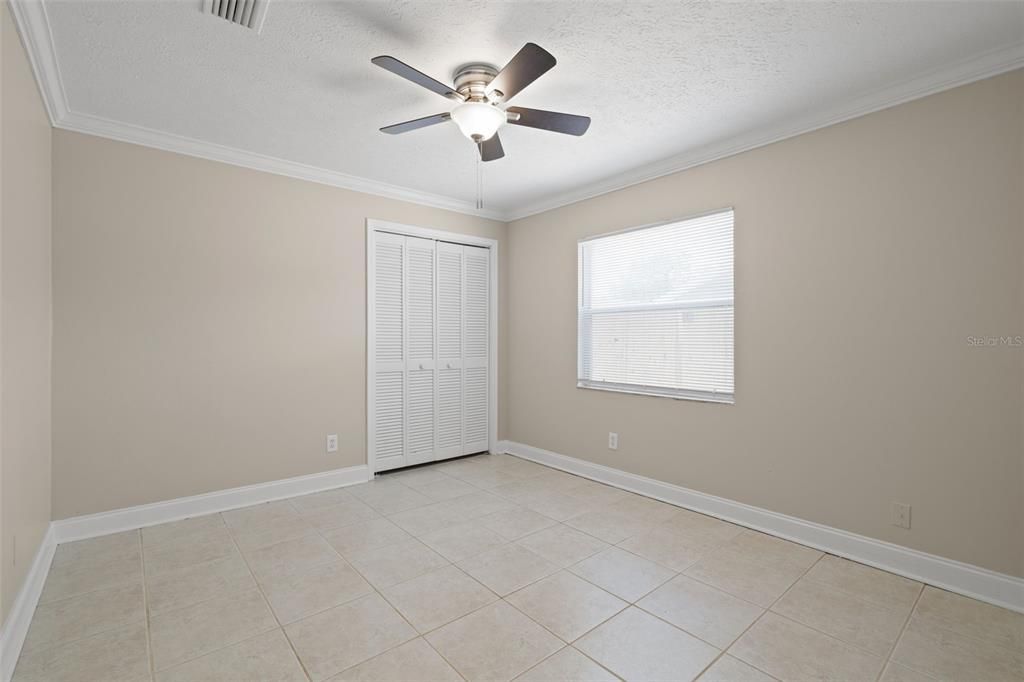 Bedroom 3 has a ceiling fan and crown molding.