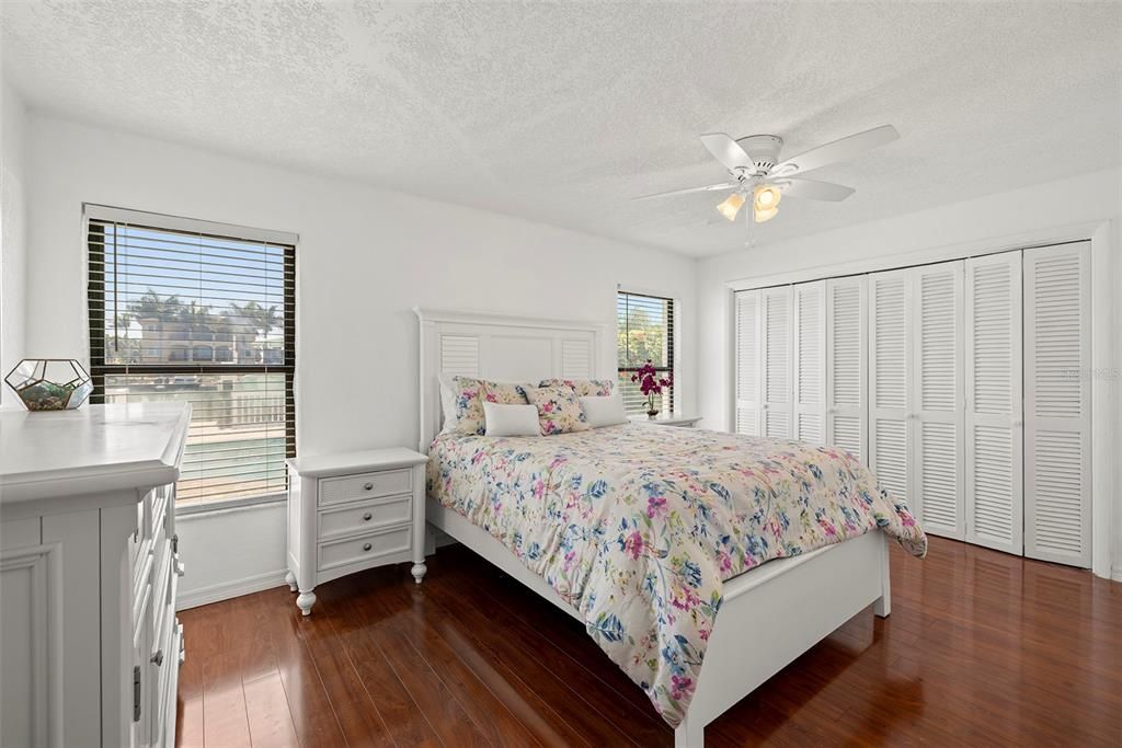 Bedroom 2 with views to the pool and water and beautiful wood floors