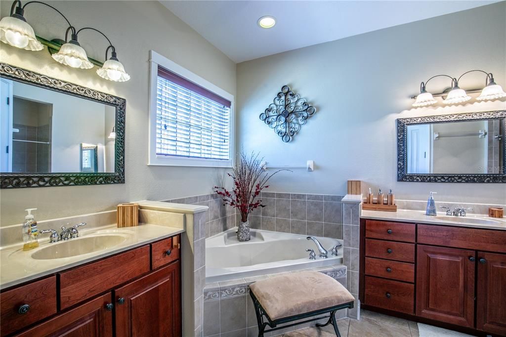 primary en suite bath has two separate vanities, water closet, and large walk in closet