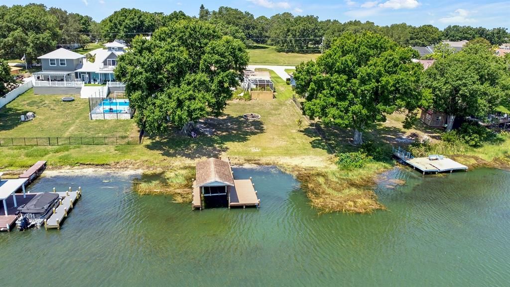 Aeriel view of boat dock and rear yard with beautiful oak tree.