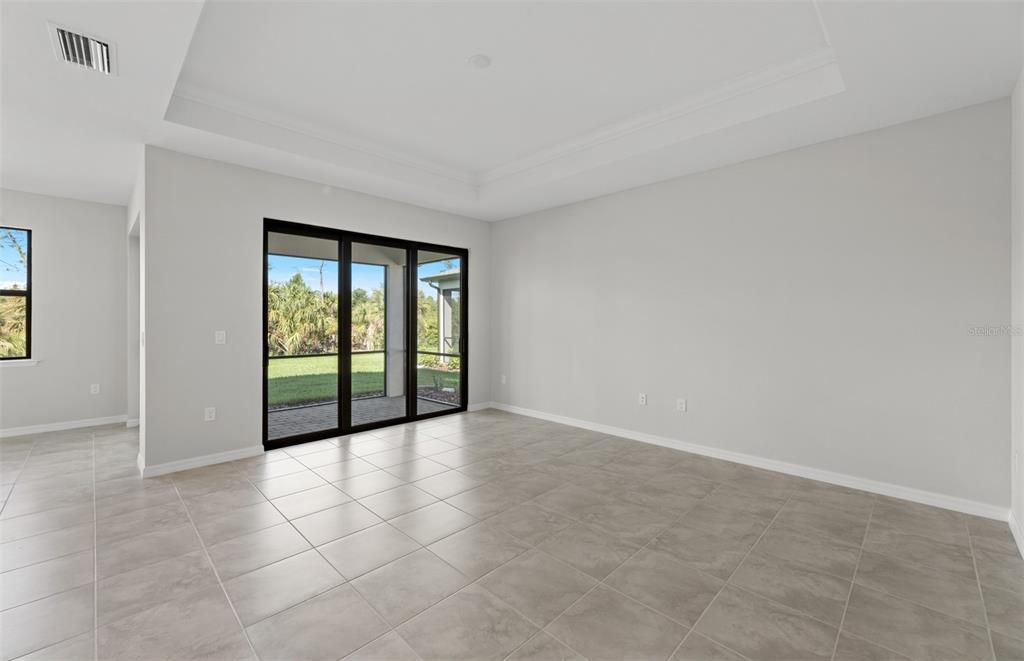 Gathering room +tray ceiling and sliding glass door onto covered lanai