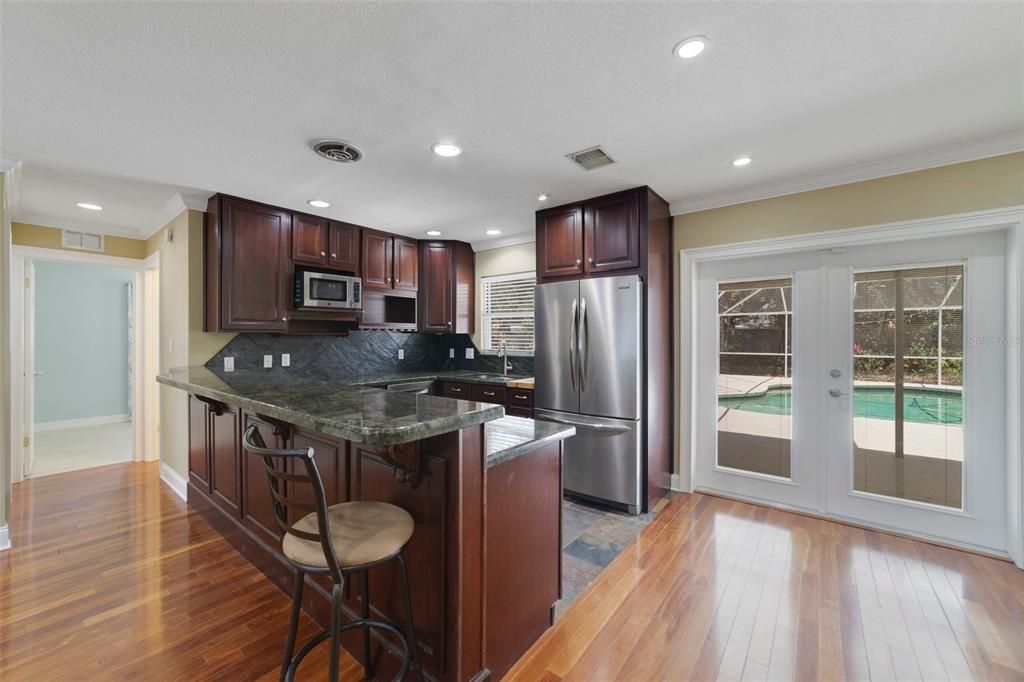 At the heart of it all you will find the well appointed kitchen offering STAINLESS STEEL APPLIANCES, a tiled backsplash that coordinates with the tile flooring, rich solid wood cabinetry and the closet pantry gives you ample storage.