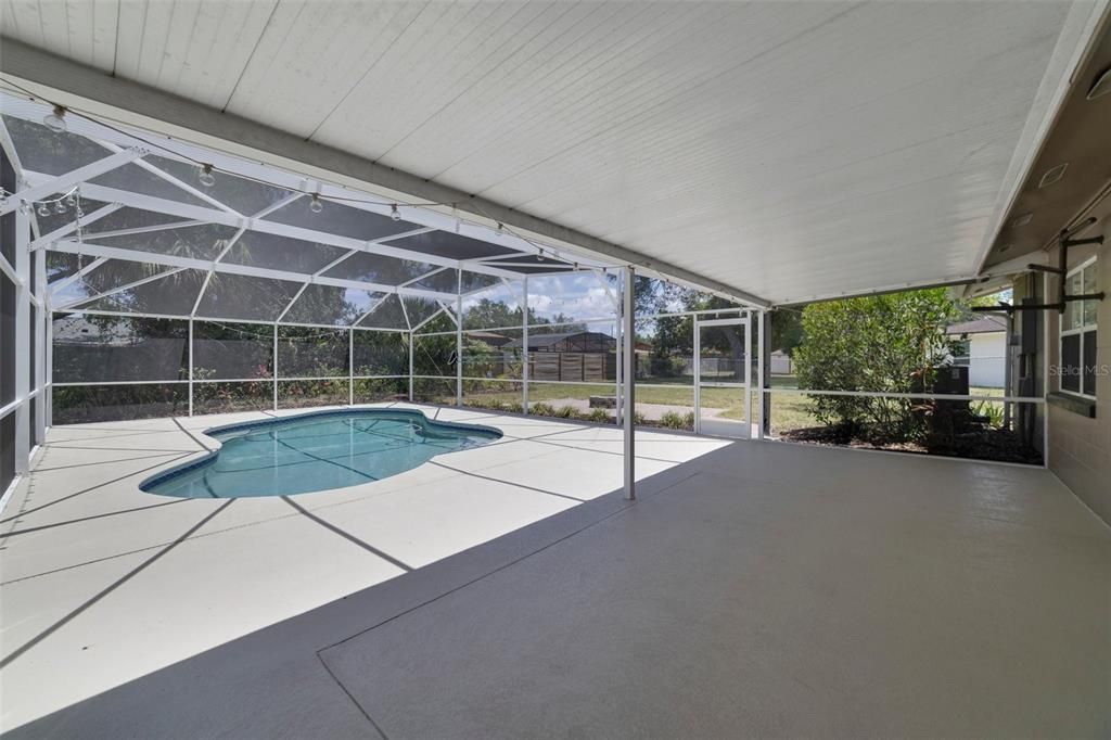 Step out onto the screened lanai and imagine a backyard oasis, with your sparkling pool at the center of it all, overlooking an expansive FENCED BACKYARD with a paver patio/fire pit and a wide variety of mature landscaping and fruit trees (lemon, lime, orange, banana, grapefruit and even pineapple plants)!