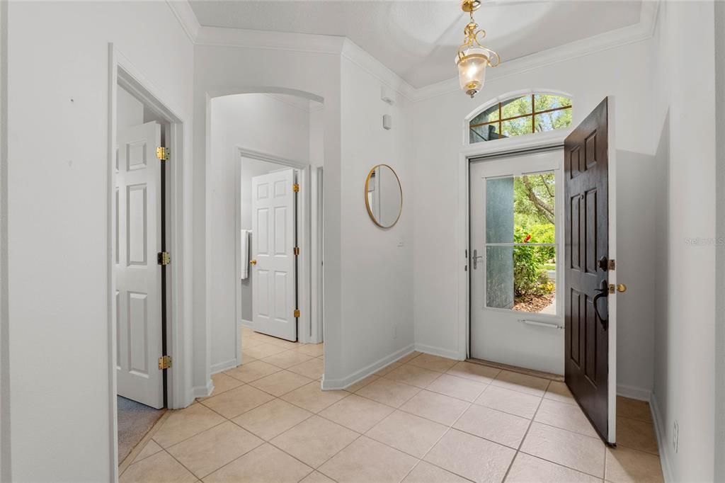 Foyer entryway w/ glass storm door, ceramic tile flooring & crown molding