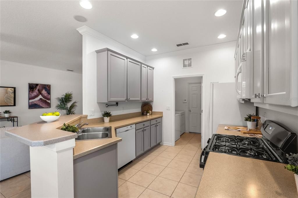 Kitchen w/ 42" wood cabinets, natural gas range, crown molding & formica counters