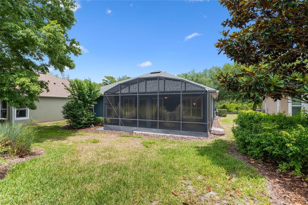 View of the screen enclosed covered patio from behind the home