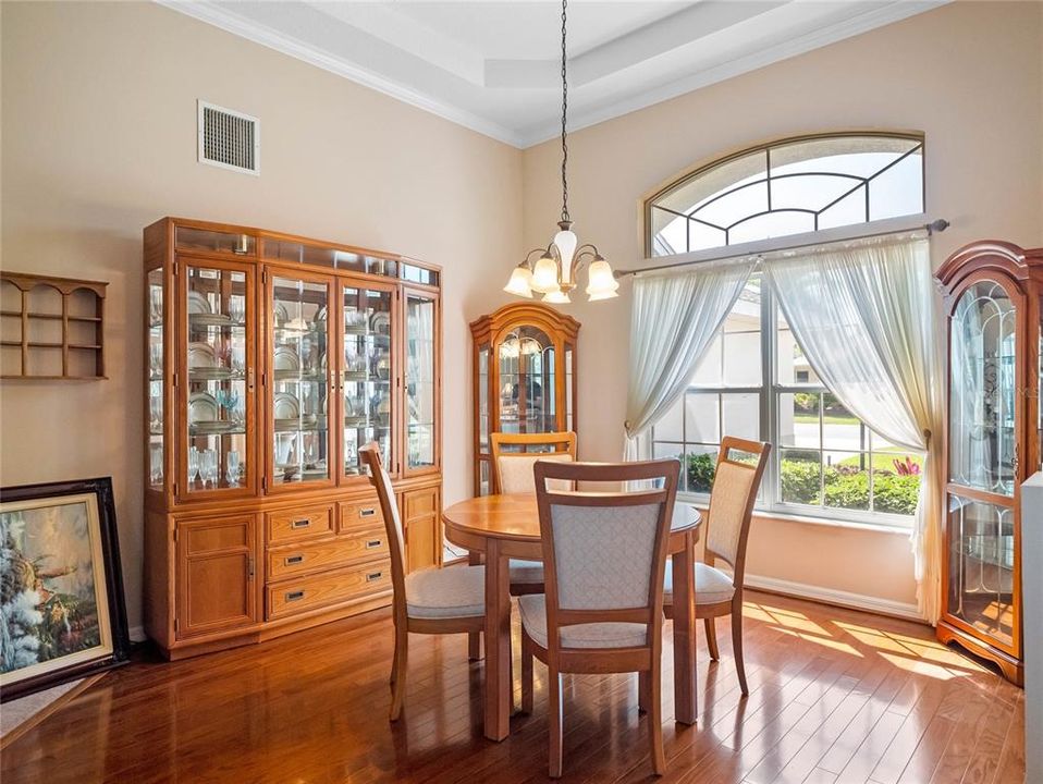 Formal Dining Area with Tray Ceilings and Wood Floors