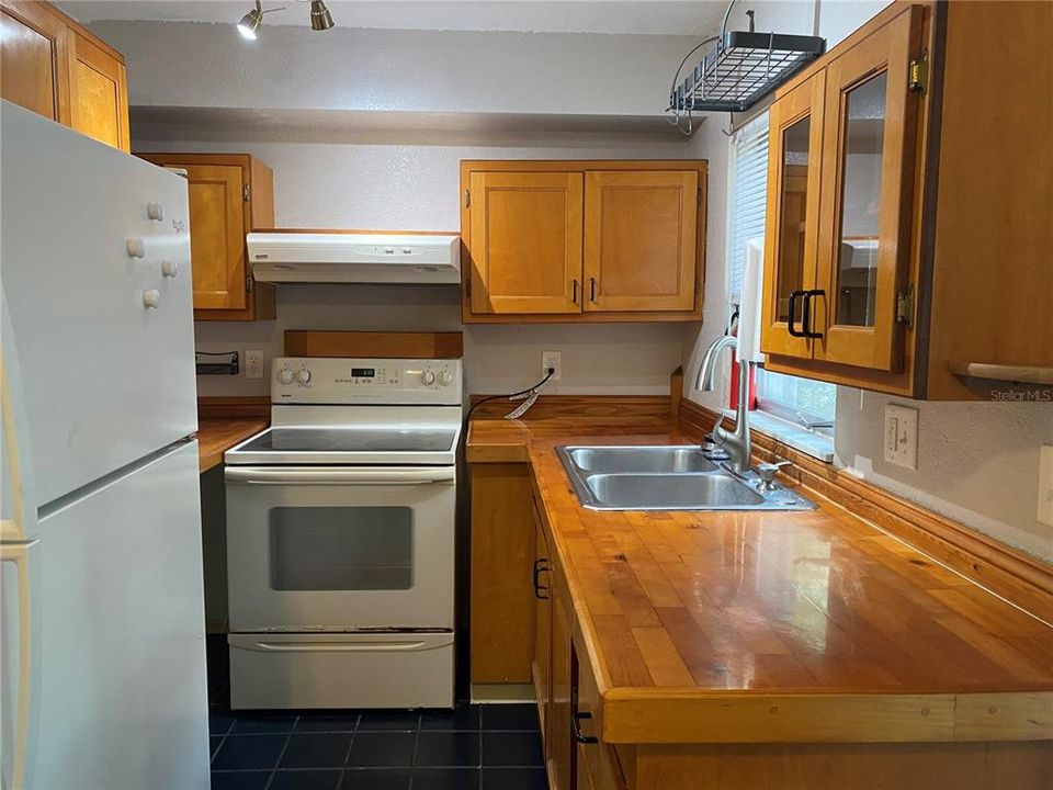 Gleaming Butcher Block Countertops, Solid Wood Cabinets, Glass Top Range