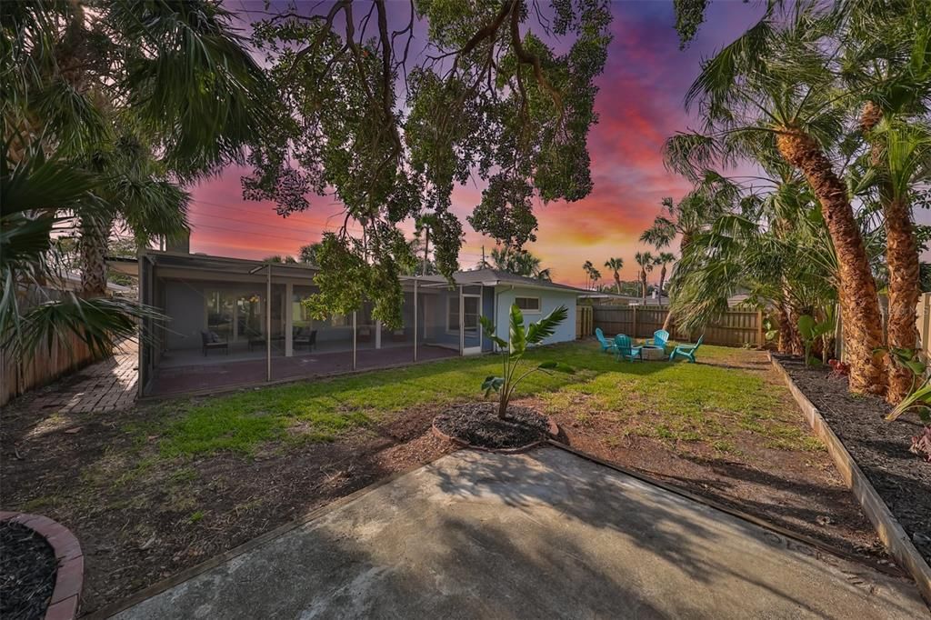 Sunset view of the rear yard and view of the oversized lanai