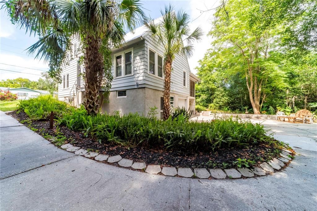 The driveway extends behind the house and into the garage area for easy access.