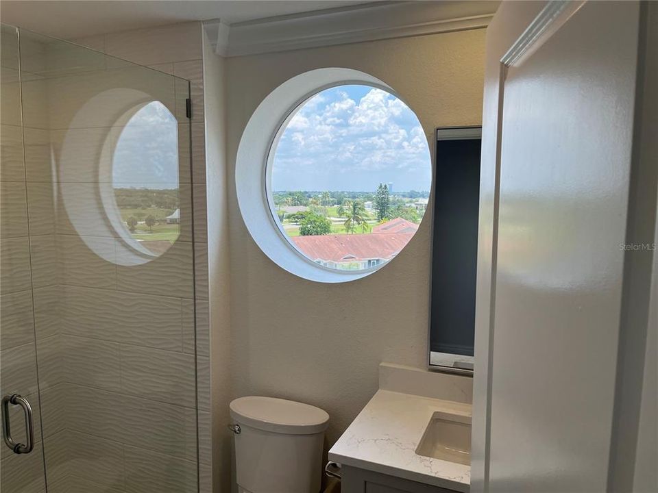 bathroom #2 has cool round window for natural light