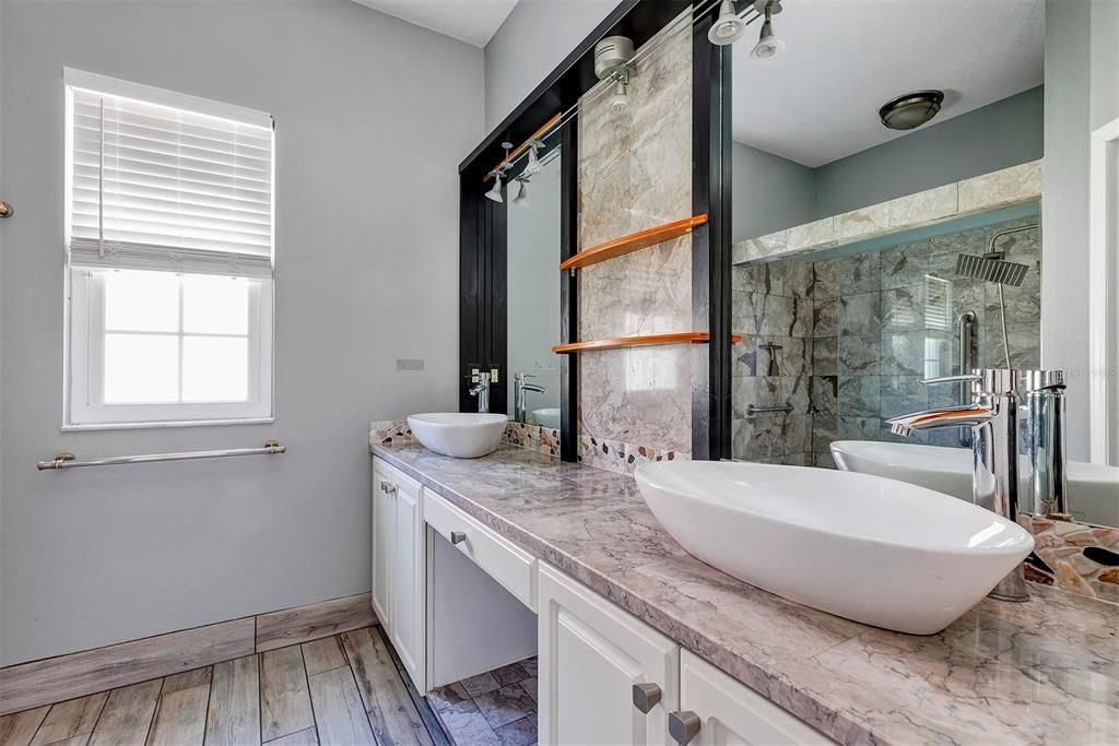 Bathroom with floating sinks and stone countertops