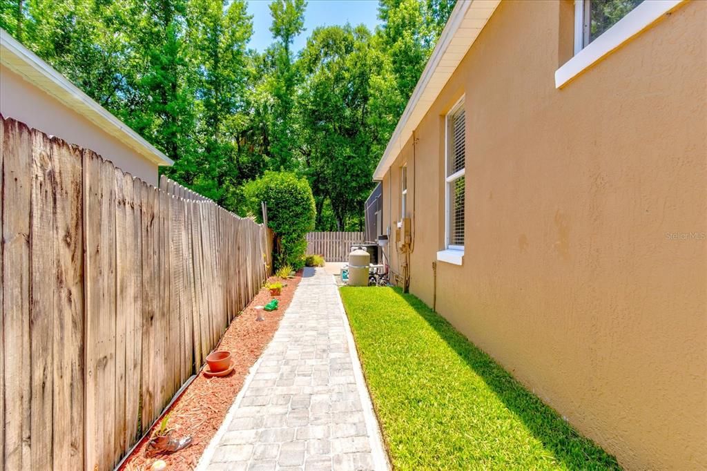 Even behind the fence: paved walkway, tidy landscaping, and a well-maintained home all around