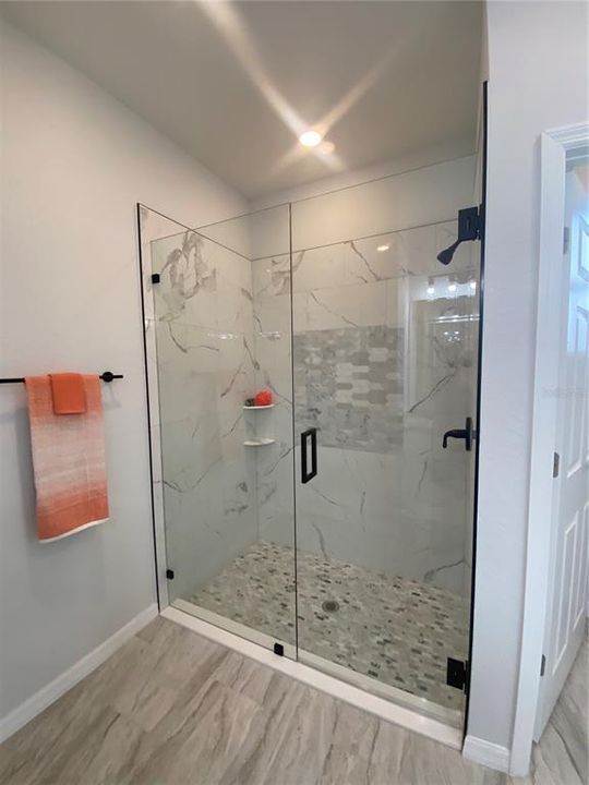 primary bath tiled walk-in shower with glass shower door
