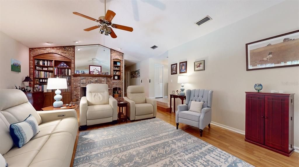 Family room with fireplace, hallway to 3 bedrooms, hall/pool bath and primary suite