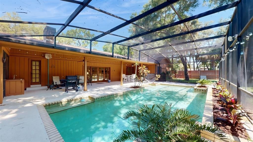 pool, lanai with door from left: bath, family room, kitchen, in-law suite